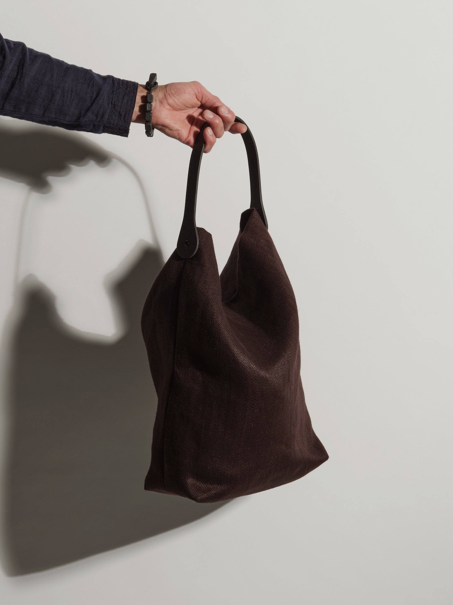 Langackerhäuslのバケット型リネンバッグBUCKET(バケット)。ヘリンボーンリネンに独自の「Tor」紙製グリップハンドルを組み合わせた、立体的なフォルムが特徴のオーストリア製ハンドメイドバッグ。