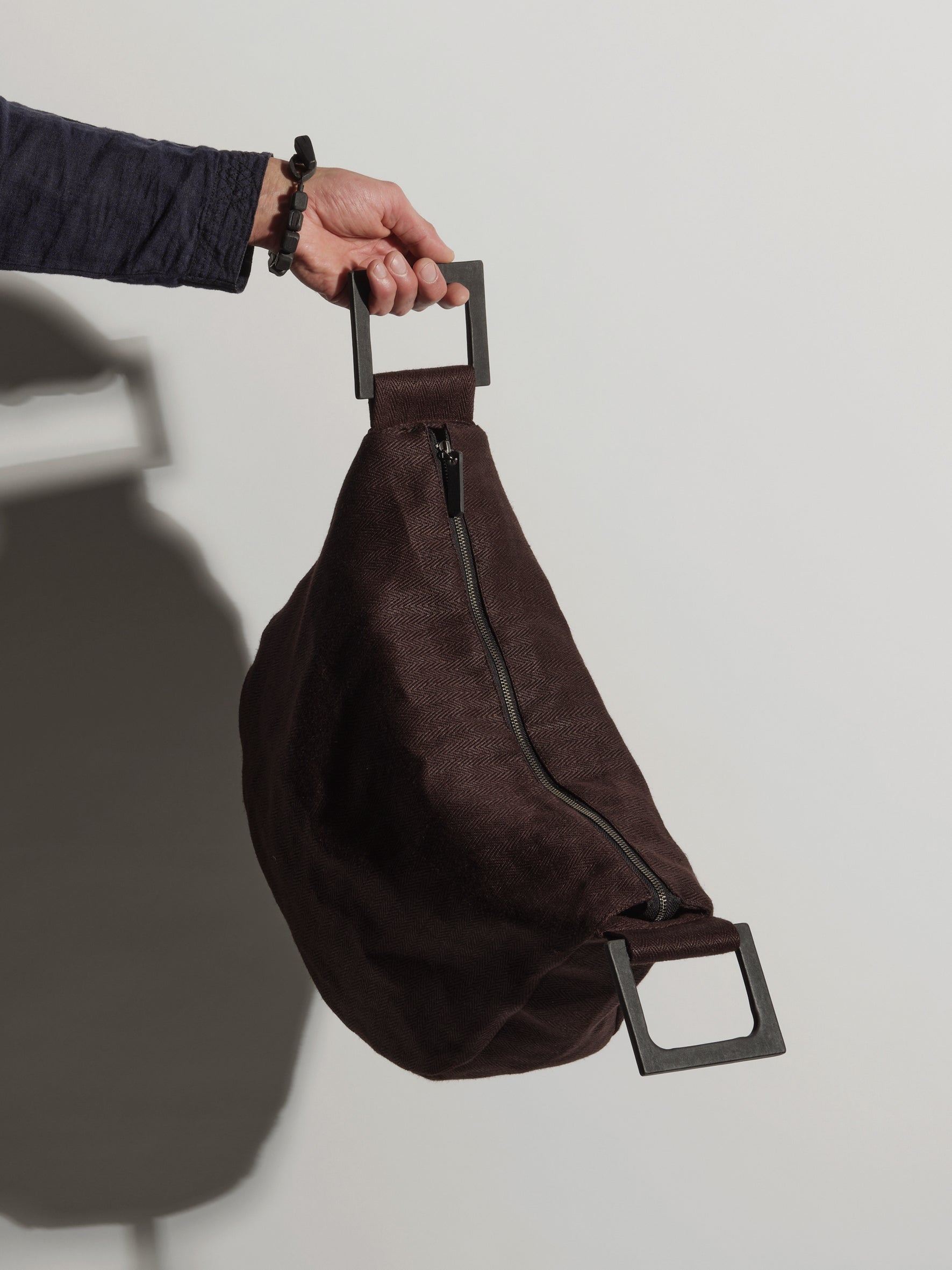 Langackerhäuslのしずく型リネンバッグDROP(ドロップ)。ヘリンボーンリネンに独自の「Tor」紙製グリップハンドルを組み合わせた、前面の垂直ファスナーが特徴のオーストリア製ハンドメイド手提げバッグ。