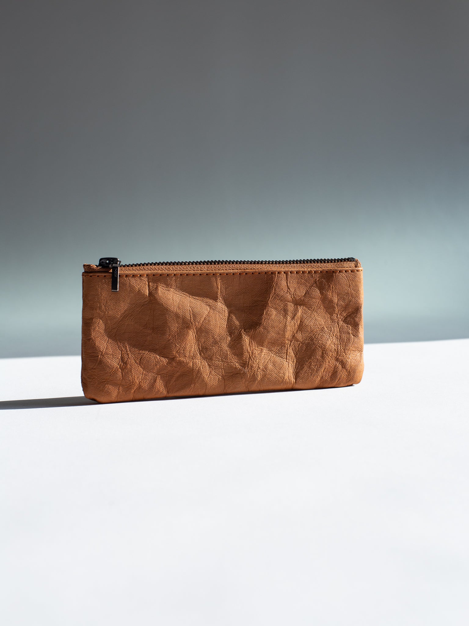 Langackerhäuslの草木染めペンシルケース(Tabakカラー)。特殊加工紙のマットな質感と、乾燥した煙草の葉のような深いブラウンが調和する、オーストリア製ハンドメイドケース。