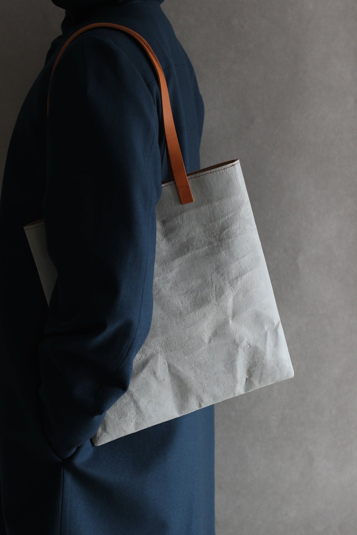 LangackerhäuslのコンクリートトートバッグSLEEVE(スリーブ)。コンクリートの質感と紙の柔軟性を併せ持つ独創的な素材を使用し、長いレザーハンドルがアクセントを添えるオーストリア製ハンドメイド縦型トート。