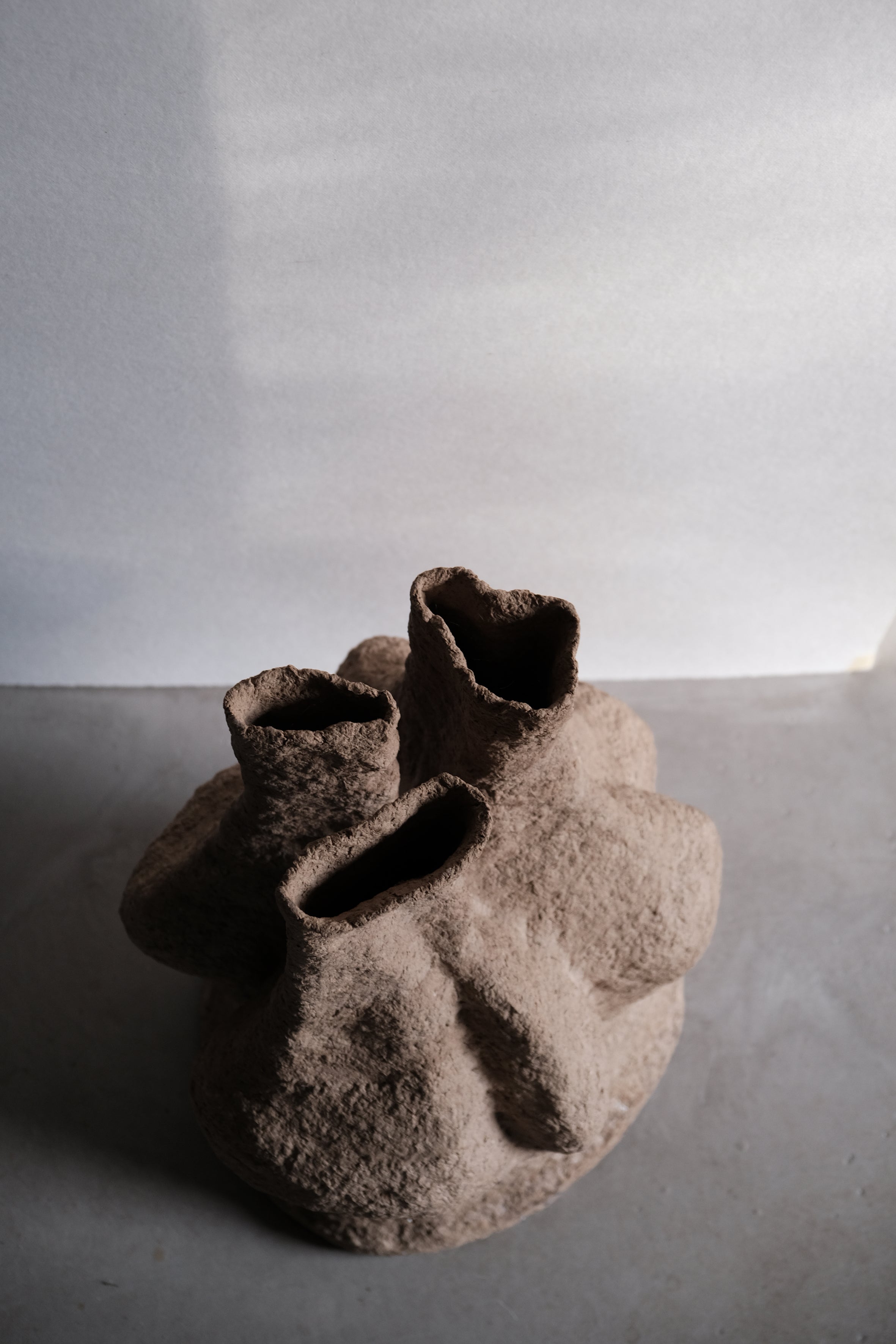 Langackerhäuslの再生紙パルプ彫刻ADOBE Table no.2。昆虫の巣をイメージした複雑なうねりと有機的な空洞が美しい、高さ53cmのハンドメイド一点ものアートテーブル。