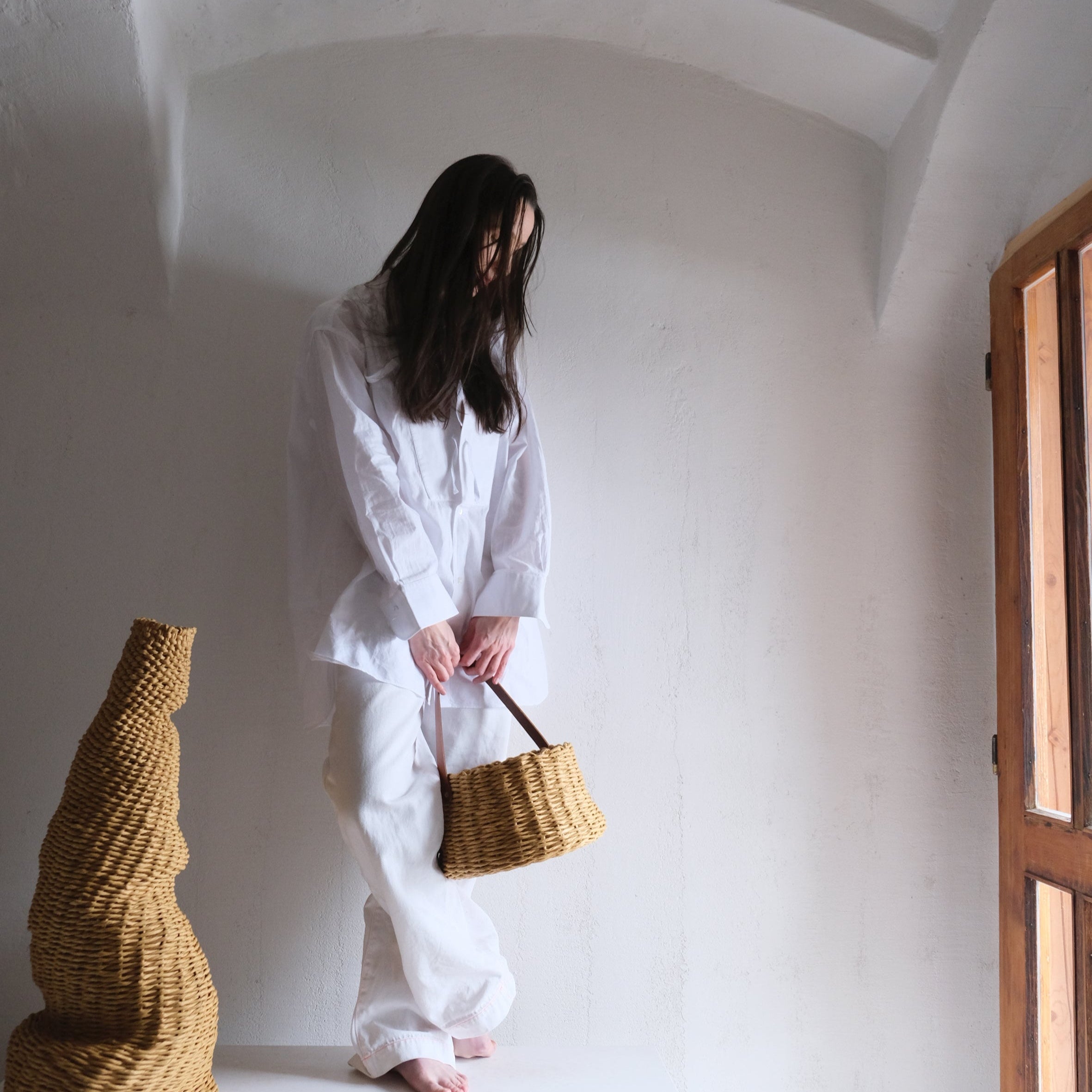 フランス製紙撚り糸をデザイナーが手編みしたCOCOON BASKET（コクーン バスケット）。丸みのある繭のようなフォルムと、真鍮金具で固定されたレザーハンドルが美しい、オーストリア製ハンドメイドのカゴバッグ。