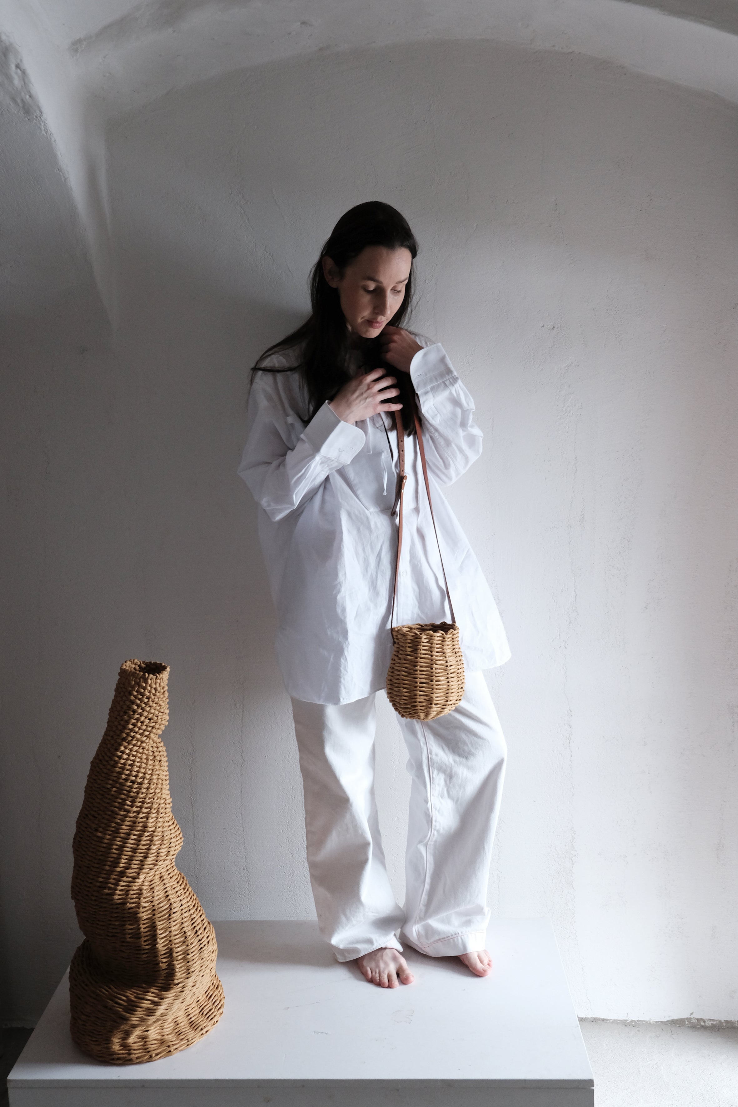 紙フランス製紙撚り糸をデザイナーが手編みしたCOCOON CROSSOVER（コクーン クロスオーバー）。繭のような丸いフォルムを一本のレザーストラップが引き立てる、オーストリア製ハンドメイドショルダーバッグ。