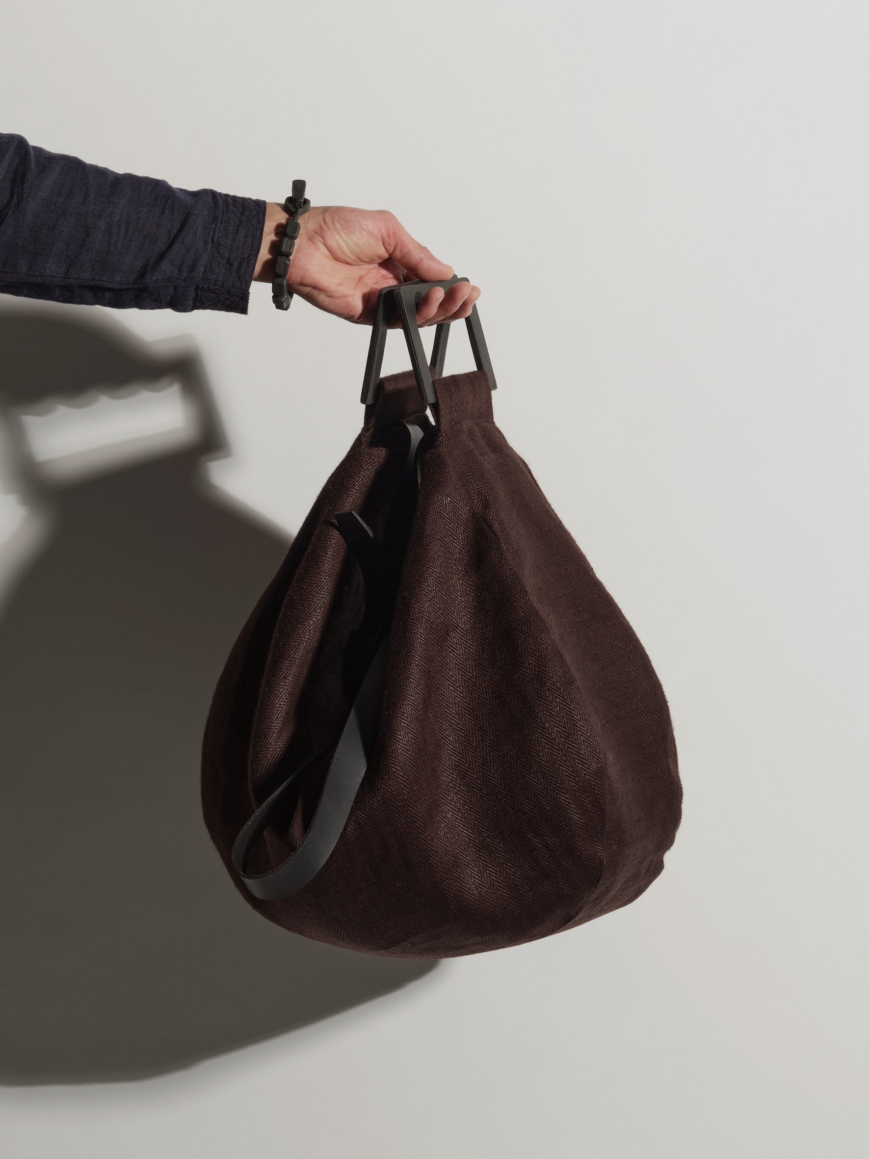 LangackerhäuslのオーバーサイズショルダーバッグDRIFTER（ドリフター）。ヘリンボーンリネンと独自の紙製ハンドルを組み合わせた、半月型のフォルムが特徴のオーストリア製ハンドメイドバッグ。