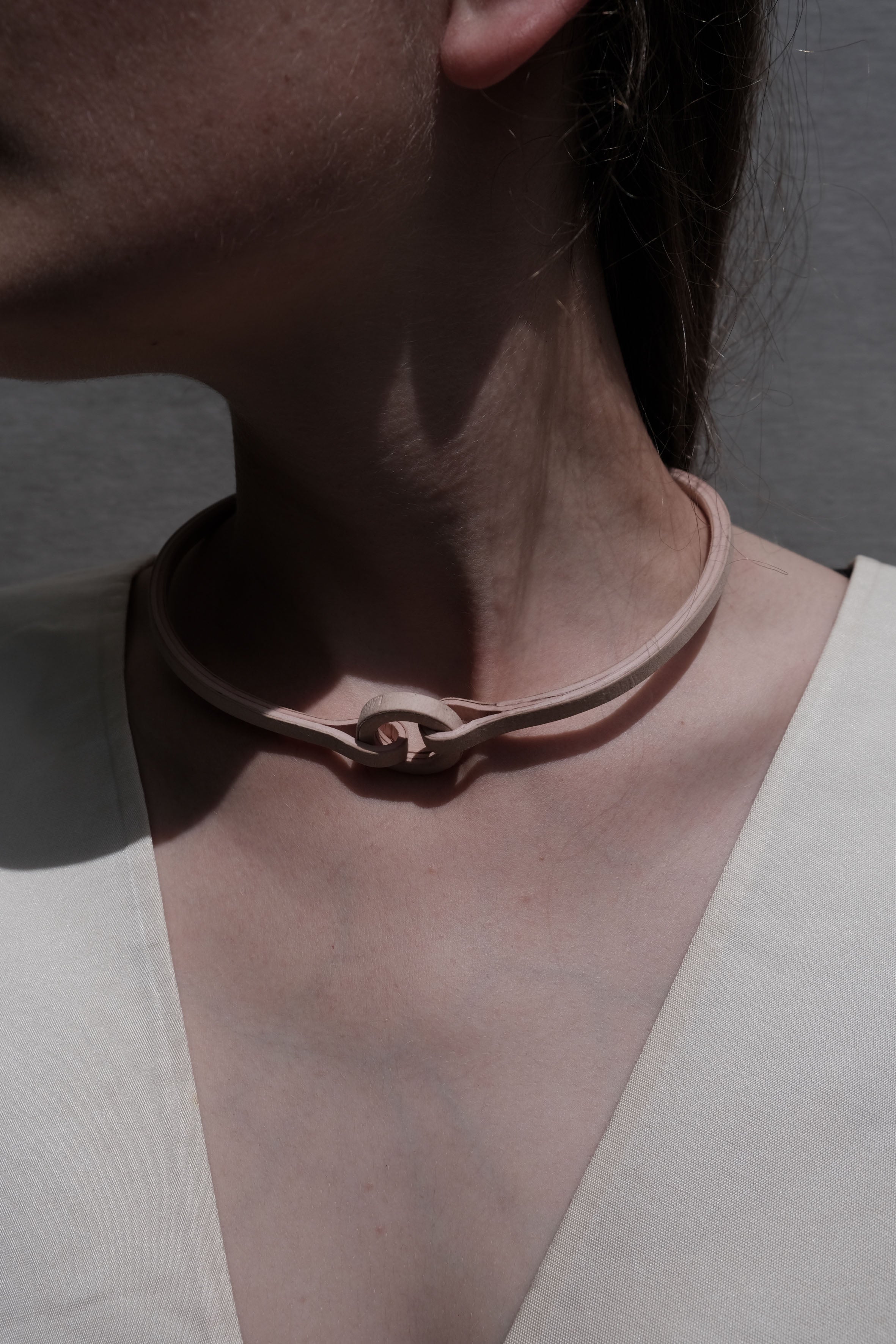 Langackerhäuslの身に纏うアート「HALSI（ハルシ）ネックレス」。一本の細いラインと中央の小さな円環モチーフが美しい、ヌードカラーの超軽量ハンドメイドチョーカー。Tバー式の留め具を採用したオーストリア製ジュエリー。